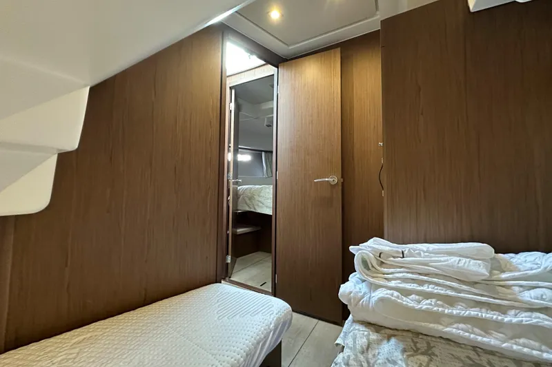  Yacht Photos Pics Interior cabin of 2019 Jeanneau Velasco 37F with wooden finish and cozy bedding.