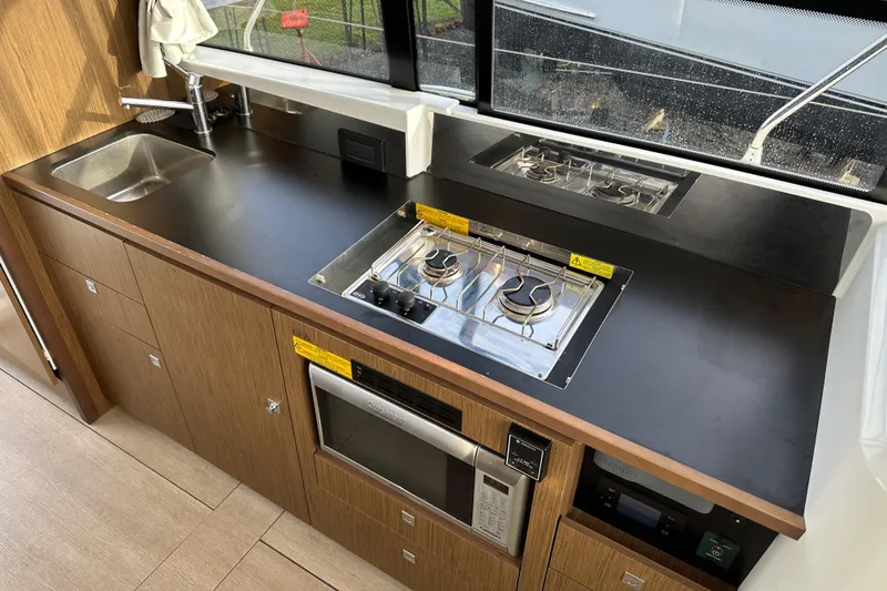  Yacht Photos Pics Modern kitchen in 2019 Jeanneau Velasco 37F yacht with stove, sink, and microwave.