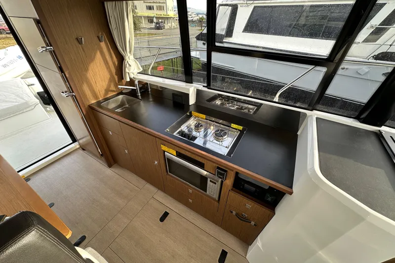  Yacht Photos Pics Modern kitchen interior of 2019 Jeanneau Velasco 37F yacht with stove and microwave.