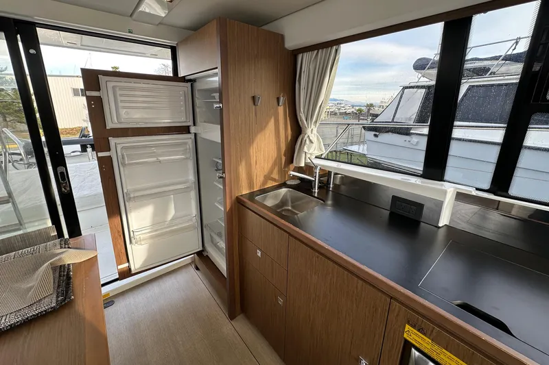  Yacht Photos Pics Interior of 2019 Jeanneau Velasco 37F yacht kitchen with open fridge and sleek countertops.