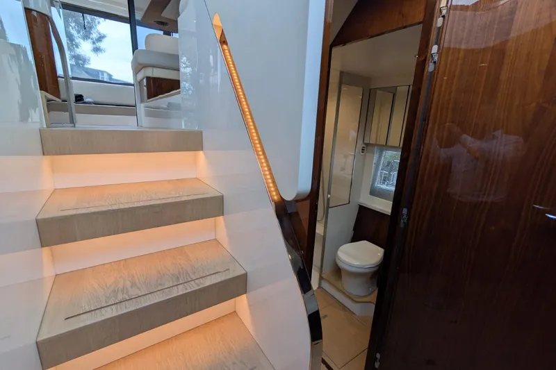 Tender Garage & Hi/lo Swimplatform Yacht Photos Pics Interior of 2022 Fairline Targa 45 GT yacht, featuring illuminated stairs and a modern bathroom.