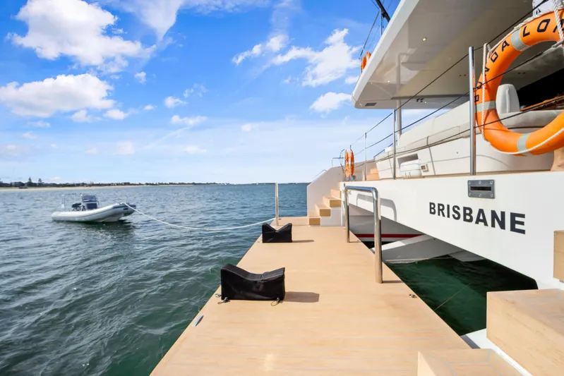 Bundalong Yacht Photos Pics 2023 McConaghy MC 82P yacht docked, with lifebuoys and tender boat in scenic waters.