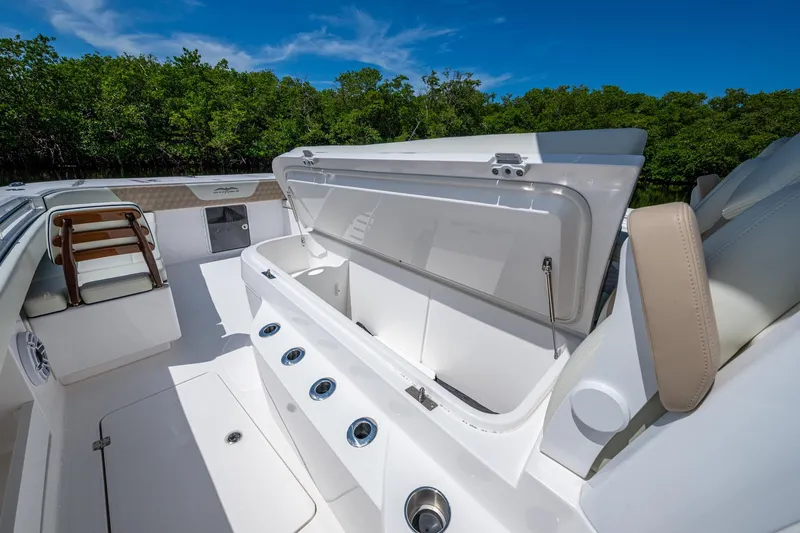 Gotta Go Yacht Photos Pics 2025 Invincible 37 Catamaran interior with open storage compartment, sleek design, and lush greenery backdrop.