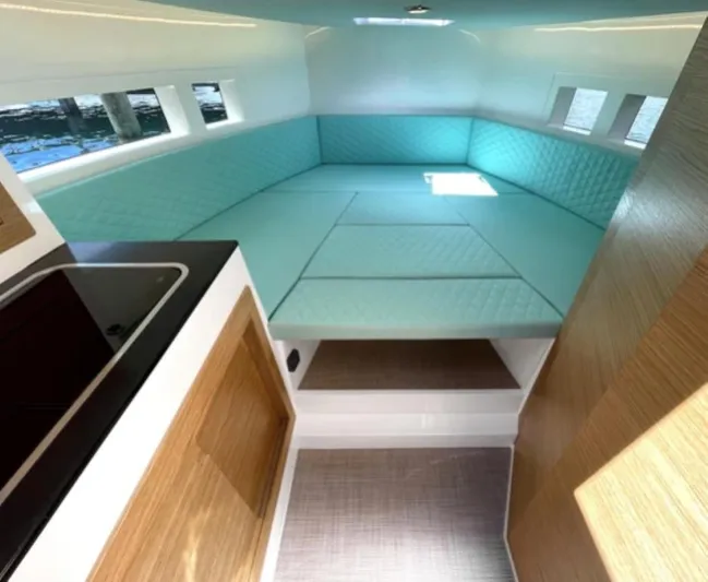  Yacht Photos Pics 2024 De Antonio Yachts D28 Cruiser interior with turquoise seating and modern kitchenette.
