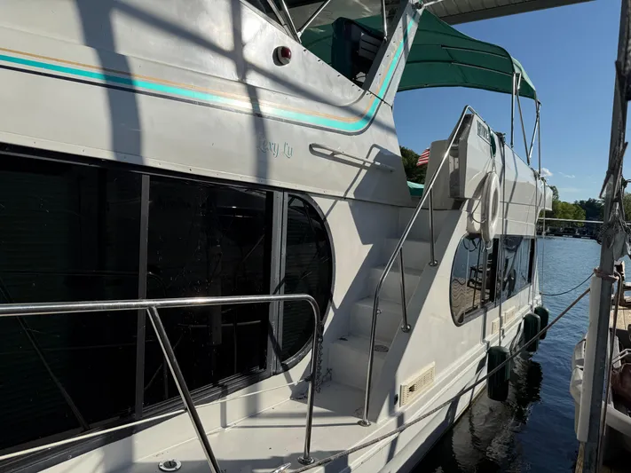 Lexy Lu Yacht Photos Pics 1996 Bluewater Yachts 52 Limited Edition docked, featuring sleek design and green canopy.