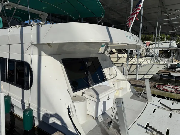 Lexy Lu Yacht Photos Pics 1996 Bluewater Yachts 52 Limited Edition docked, featuring a spacious deck and American flag.