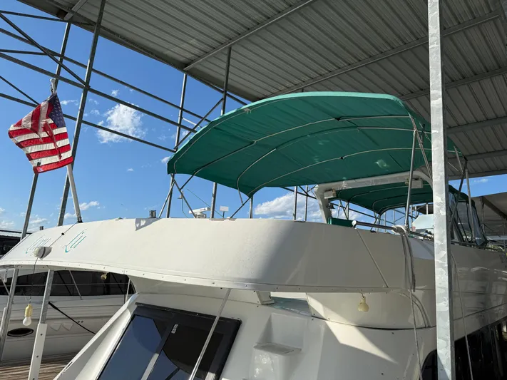 Lexy Lu Yacht Photos Pics 1996 Bluewater Yachts 52 Limited Edition under a canopy with American flag.