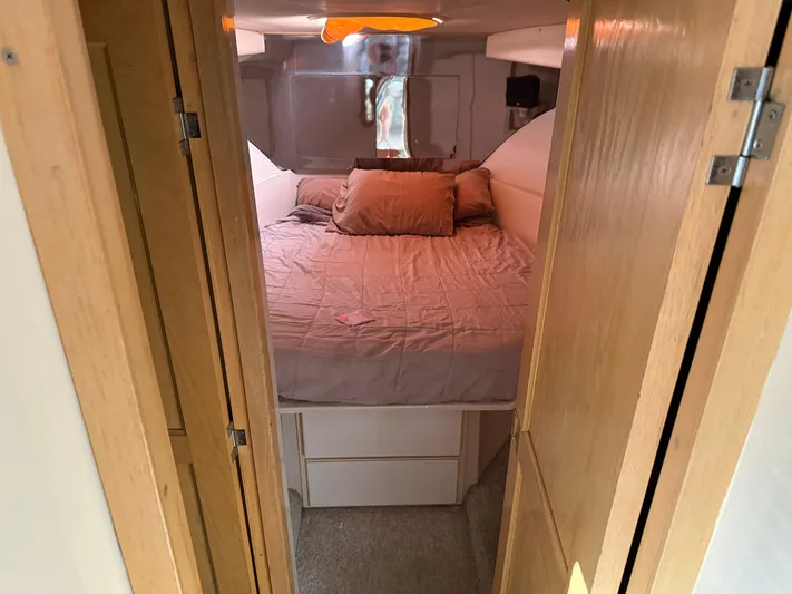 Lexy Lu Yacht Photos Pics Cozy bedroom in 1996 Bluewater Yachts 52 Limited Edition, featuring a comfortable bed and wooden accents.