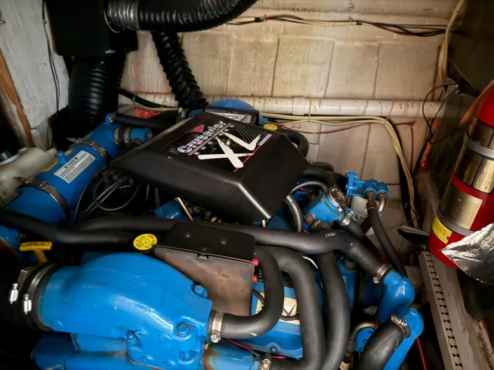 Lexy Lu Yacht Photos Pics Engine compartment of a 1996 Bluewater Yachts 52 Limited Edition, featuring a blue marine engine.