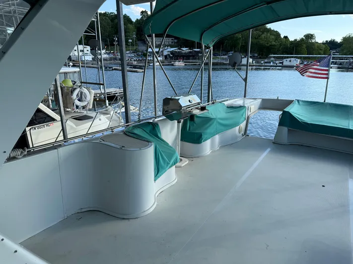 Lexy Lu Yacht Photos Pics 1996 Bluewater Yachts 52 Limited Edition deck with seating, grill, and American flag.
