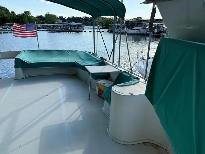 Lexy Lu Yacht Photos Pics 1996 Bluewater Yachts 52 Limited Edition boat deck with green canopy and American flag.