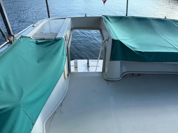 Lexy Lu Yacht Photos Pics 1996 Bluewater Yachts 52 Limited Edition deck with green covers, overlooking water.