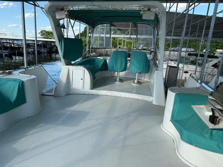 Lexy Lu Yacht Photos Pics 1996 Bluewater Yachts 52 Limited Edition with teal seating, docked under a canopy.