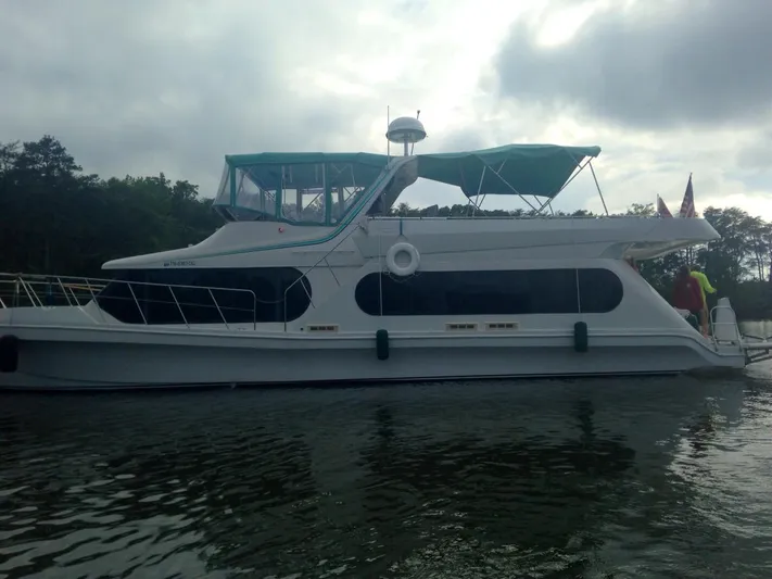 Lexy Lu Yacht Photos Pics 1996 Bluewater Yachts 52 Limited Edition on calm water, featuring teal canopy and sleek design.