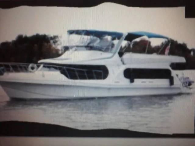 Lexy Lu Yacht Photos Pics 1996 Bluewater Yachts 52 Limited Edition cruising on calm waters with a blue canopy.