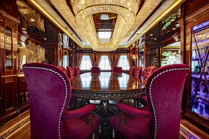 Richar Yacht Photos Pics Luxurious yacht interior with elegant dining area, featuring plush red chairs and ornate chandeliers, CRN 185.