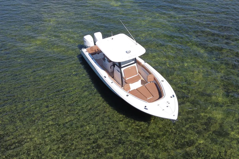  Yacht Photos Pics 2022 Sea Hunt Ultra 305 SE boat on clear green water, aerial view.