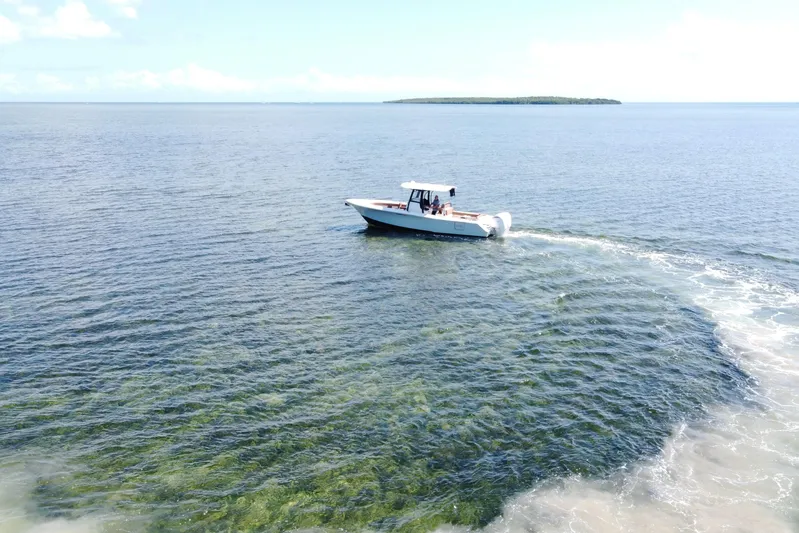 Yacht Photos Pics 2022 Sea Hunt Ultra 305 SE cruising on clear blue ocean waters.