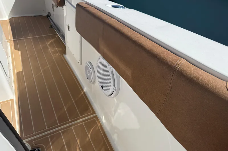  Yacht Photos Pics 2022 Sea Hunt Ultra 305 SE boat interior with brown cushioned seating and wood-patterned flooring.