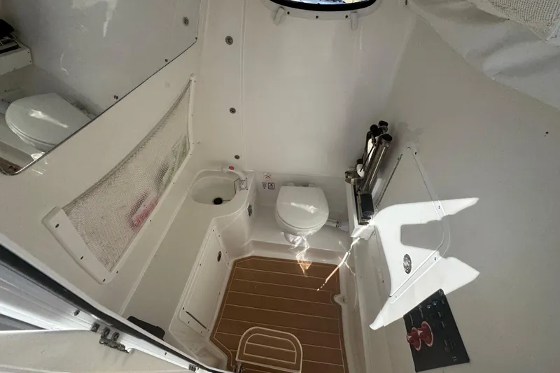  Yacht Photos Pics Interior of 2022 Sea Hunt Ultra 305 SE boat, featuring a compact bathroom with toilet and sink.
