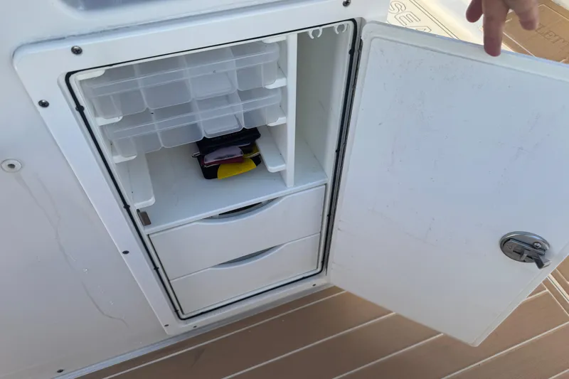  Yacht Photos Pics Open storage compartment on 2022 Sea Hunt Ultra 305 SE boat, featuring organized shelves and drawers.