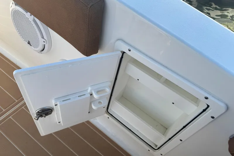  Yacht Photos Pics Open storage compartment on 2022 Sea Hunt Ultra 305 SE boat with speaker nearby.