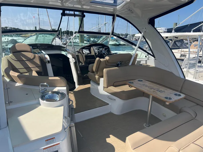 Knot A Care Yacht Photos Pics 2015 Cruisers Yachts 350 Express interior with beige seating and helm, docked at marina.