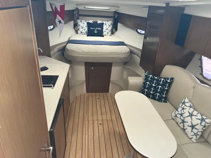Knot A Care Yacht Photos Pics 2015 Cruisers Yachts 350 Express cabin interior with bed, seating, and nautical decor.