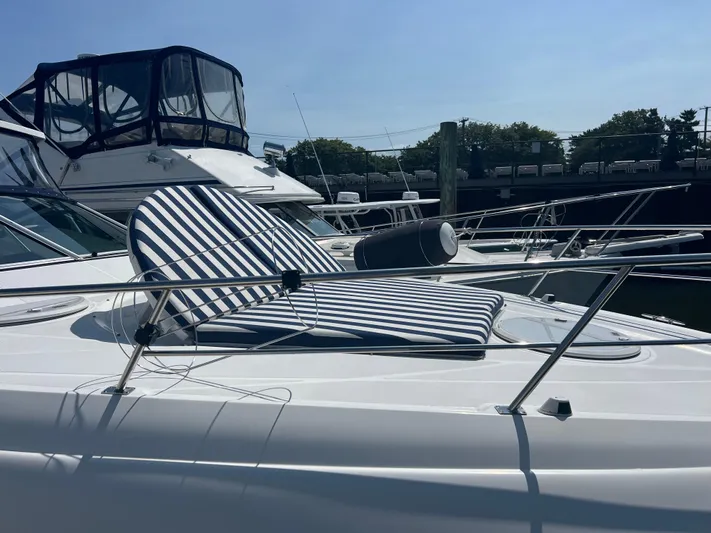 Knot A Care Yacht Photos Pics 2015 Cruisers Yachts 350 Express with striped deck chair, docked in marina.
