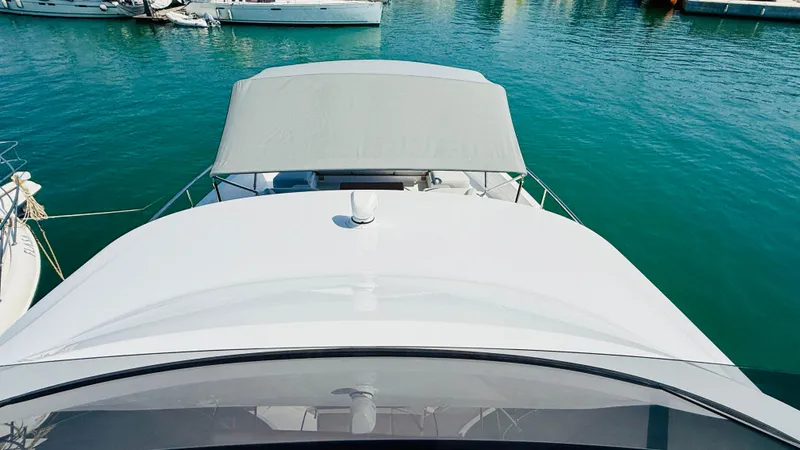  Yacht Photos Pics 2025 Azimut Magellano 60 yacht with canopy, docked in clear blue water.