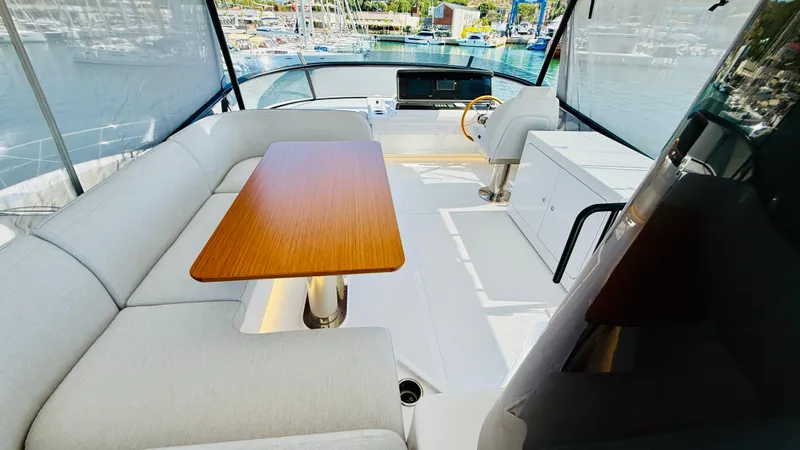  Yacht Photos Pics Luxurious interior of 2025 Azimut Magellano 60 yacht with elegant seating and wooden table.