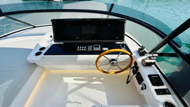  Yacht Photos Pics Cockpit of 2025 Azimut Magellano 60 yacht with modern controls and wooden steering wheel.