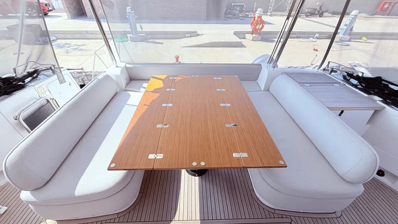  Yacht Photos Pics Interior of 2025 Azimut Magellano 60 yacht with elegant seating and wooden table.