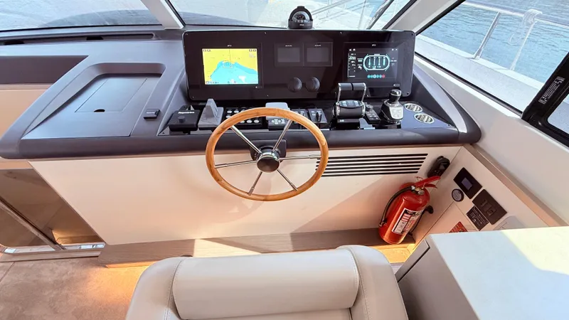  Yacht Photos Pics Helm of 2025 Azimut Magellano 60 yacht with navigation screens and wooden steering wheel.