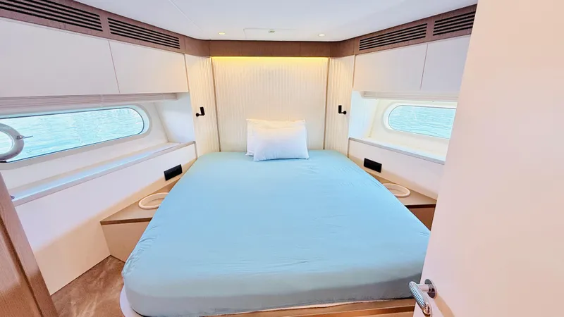  Yacht Photos Pics Luxurious bedroom interior of 2025 Azimut Magellano 60 yacht with ocean view windows.
