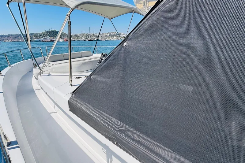  Yacht Photos Pics 2025 Azimut Magellano 60 yacht deck with sunshade and seating, docked in a marina.