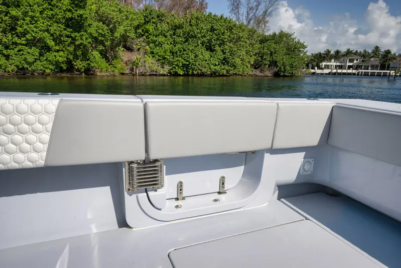 O'fishal Business Yacht Photos Pics 2025 Contender 44 ST boat interior with sleek seating, near lush greenery and waterfront homes.