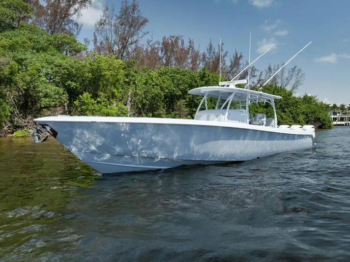 O'fishal Business Yacht Photos Pics 2025 Contender 44 ST boat on calm water, surrounded by lush greenery.