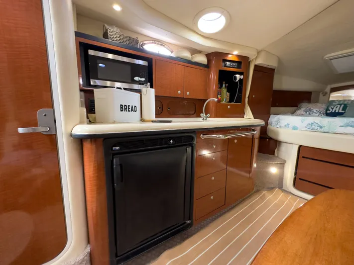  Yacht Photos Pics Luxurious 2005 Sea Ray 340 Sundancer cabin interior with kitchenette and cozy sleeping area.