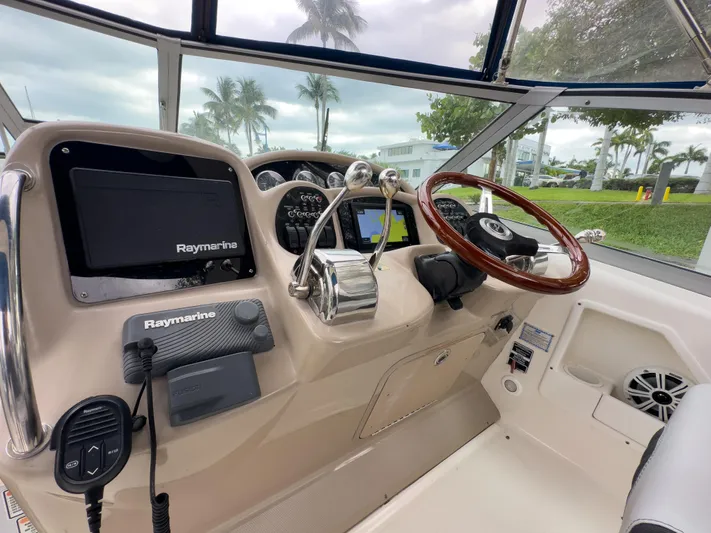  Yacht Photos Pics 2005 Sea Ray 340 Sundancer helm with Raymarine electronics and wooden steering wheel.