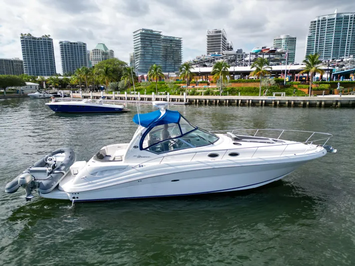  Yacht Photos Pics 2005 Sea Ray 340 Sundancer yacht docked in urban marina with city skyline.