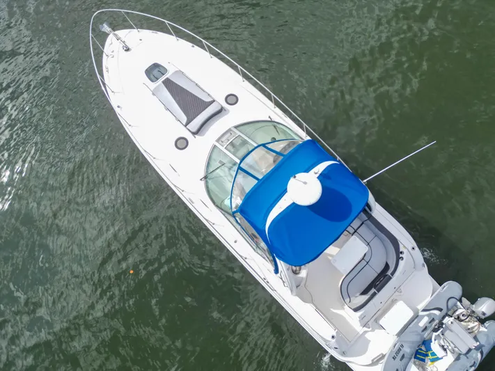  Yacht Photos Pics Aerial view of 2005 Sea Ray 340 Sundancer boat with blue canopy on water.
