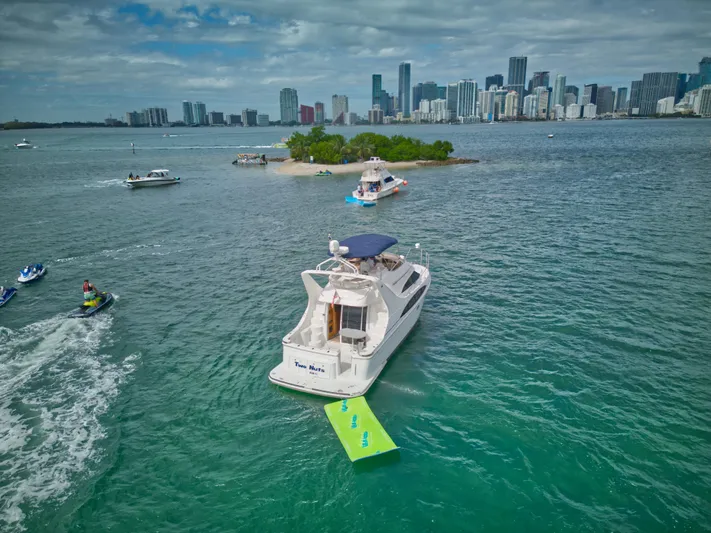  Yacht Photos Pics 2002 Carver 410 Sport Sedan yacht on water near city skyline and small island.