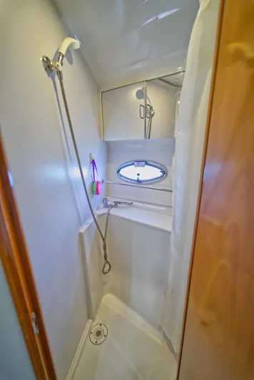  Yacht Photos Pics Shower area in 2002 Carver 410 Sport Sedan yacht, featuring compact design and porthole window.