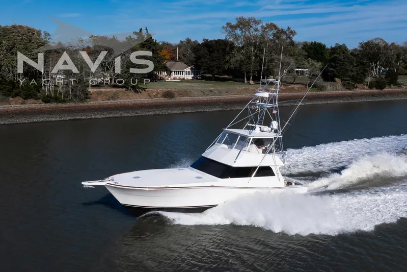 Covert Mission Yacht Photos Pics 1998 Viking 58 Convertible yacht cruising on a ICM in Cape May, surrounded by lush greenery.