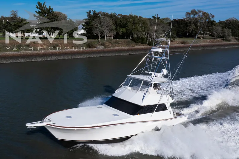 Covert Mission Yacht Photos Pics 1998 Viking 58 Convertible yacht cruising ICW, surrounded by lush greenery.