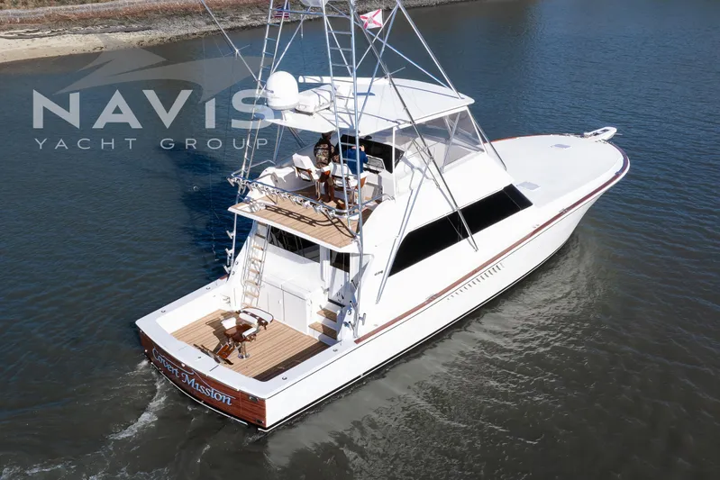 Covert Mission Yacht Photos Pics 1998 Viking 58 Convertible yacht cruising on calm waters, rear view.