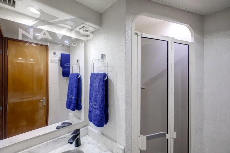 Covert Mission Yacht Photos Pics Bathroom interior of 1998 Viking 58 Convertible yacht with blue towels and modern fixtures.