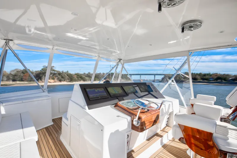 Covert Mission Yacht Photos Pics Luxurious 1998 Viking 58 Convertible yacht helm with modern navigation equipment and scenic waterway view.