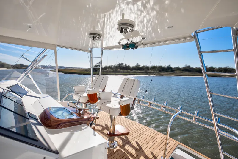 Covert Mission Yacht Photos Pics Luxurious 1998 Viking 58 Convertible yacht interior with helm and seating, overlooking serene waters.